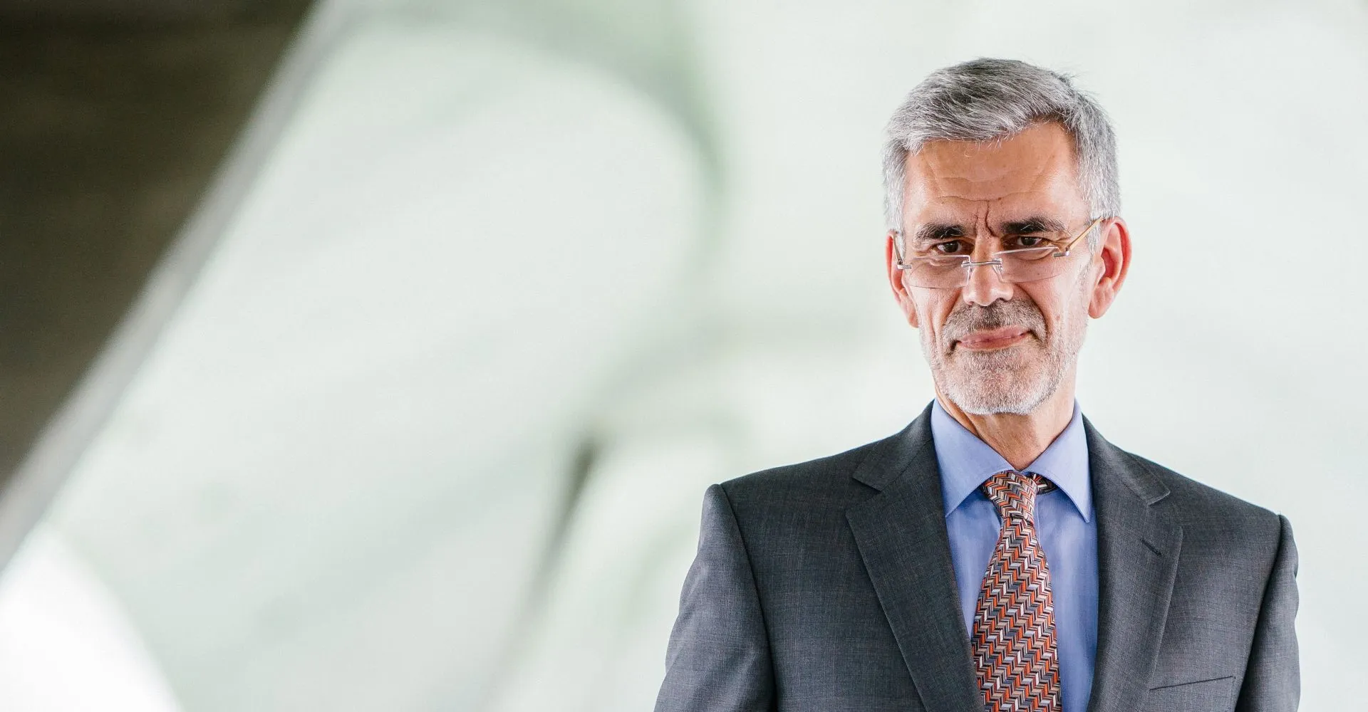 Experienced executive in a suit against a bright office background